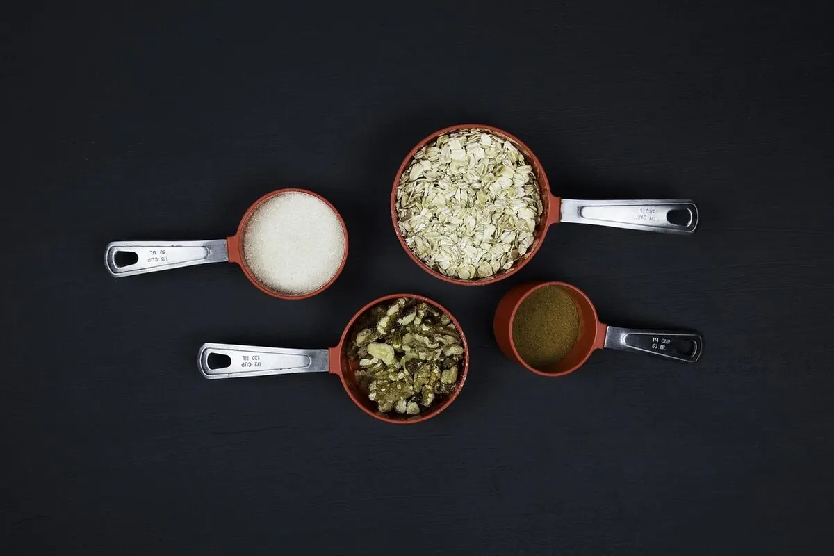 Measuring cups on a kitchen counter for liquid volume conversion from gallons to quarts