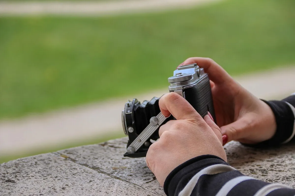 Photographer holding a camera correctly with both hands to reduce camera shake