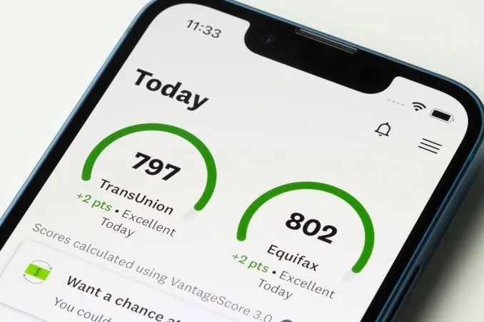 Credit Karma app on a phone showing TransUnion and Equifax scores calculated using VantageScore 3.0