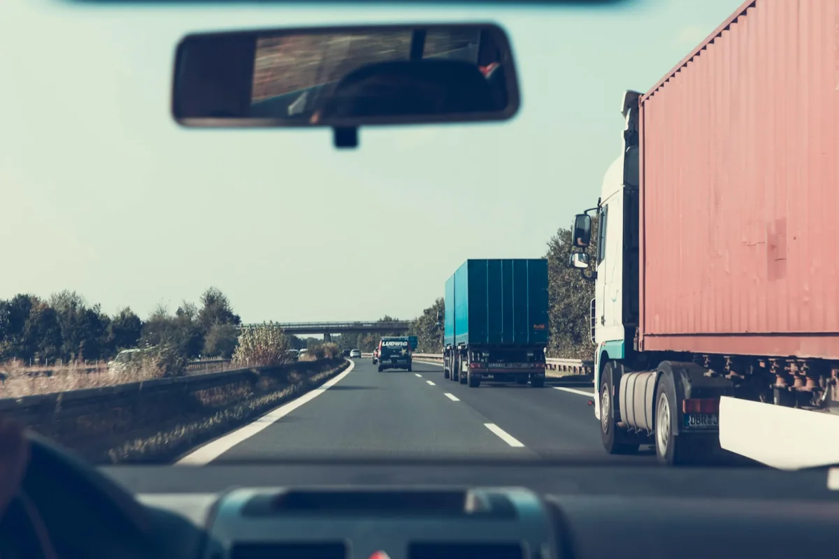 View through a vehicle windscreen of trucks on a motorway